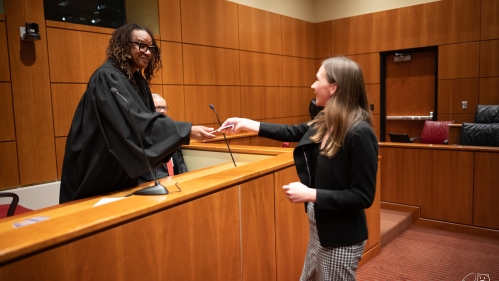 Judge shaking student’s hand from bench