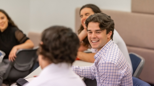 Student smiling at other students in class.