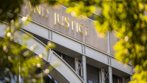 A close-up of the word "Justice" engraved on an exterior of a building at Rutgers Law School.