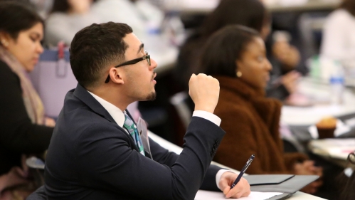 A young man takes note while attending class at Rutgers Law School.