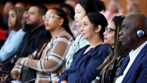 A row of people of different ethnicities and genders in the audience of an event at Rutgers Law School.