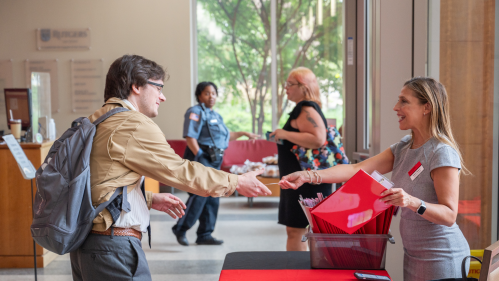 woman handing man information across table in lobby