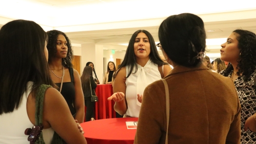 A group of students get to know each other around a cocktail table.