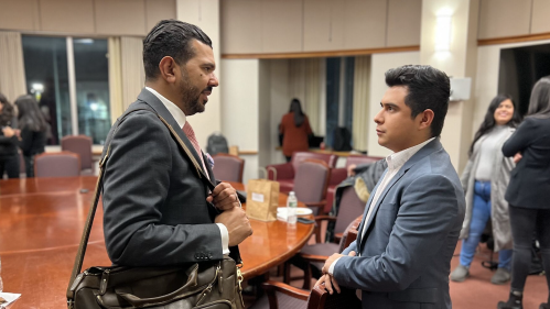 Two male Rutgers alum interface at a meet-and-greet.