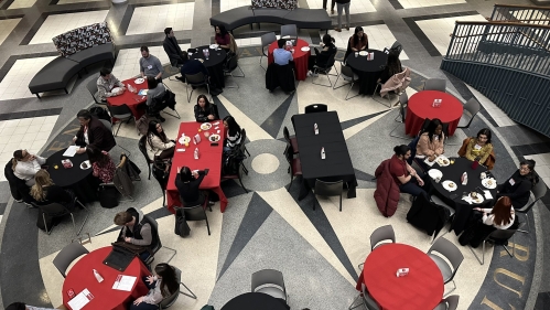 An atrium full of red and black tables for a large event.