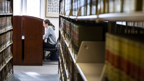 A Rutgers Law student studies at a desk in a library.