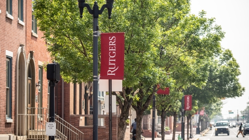 A busy street at Rutgers University with crimson banners.