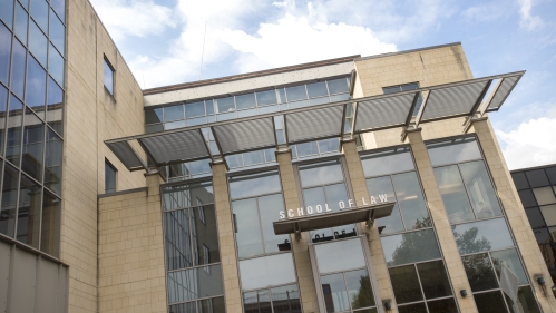 An angled perspective of the exterior of a glassy Rutgers Law Building, with the focal point being an entrance.