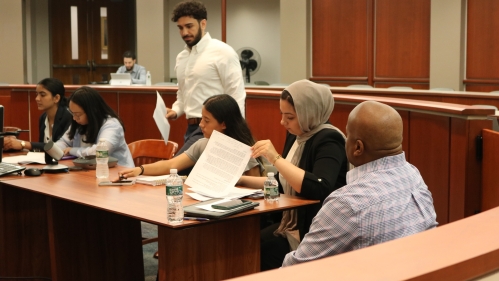 students in mock courtroom looking at papers
