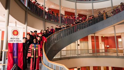 people in red commencement regalia lined up on stairwell