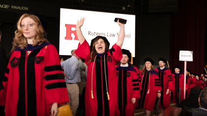 people in line wearing red graduation robes and black caps