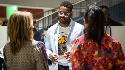 Student speaking with two alumni