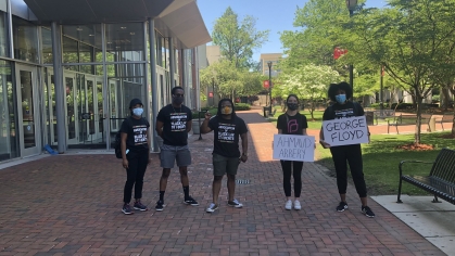 Students holding protest signs in front of law school