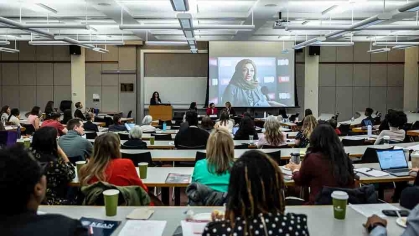 Large classroom with people looking at large projector in the front
