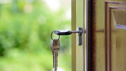 Key inside keyhole of brown door