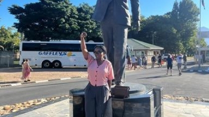 woman posing for a photograph in front of a statue