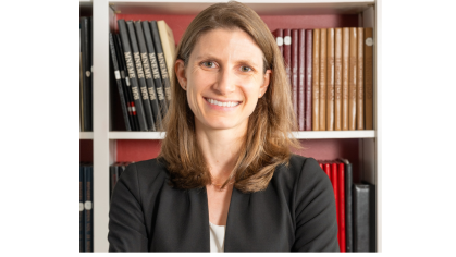 woman smiling in front of bookcase