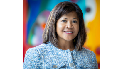 woman smiling in front of colorful mural