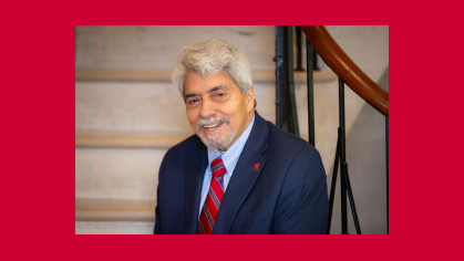 man smiling in blue business suit sitting on stairs indoors 