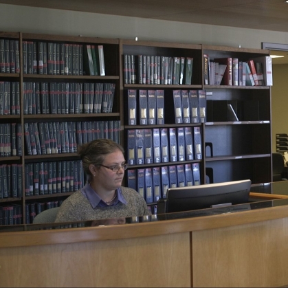 Librarian behind desk in library