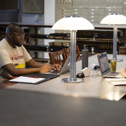 Man and woman sitting across from each other in library