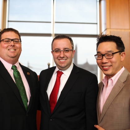 Three men standing and smiling