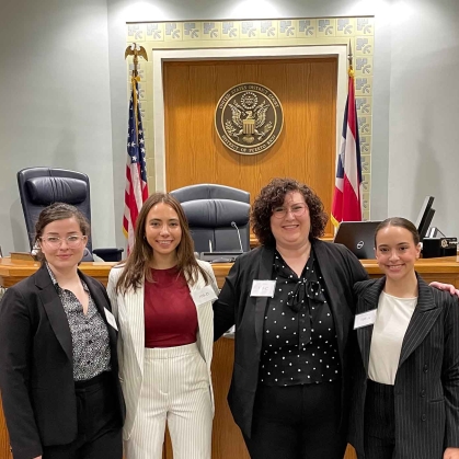 Four women standing side by side in courtroom