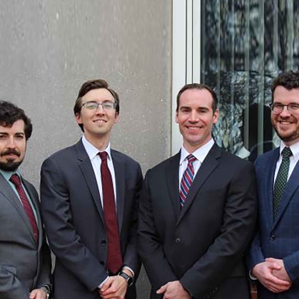 Four men in suits standing next to each other.