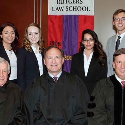 Robed judges seated in front of moot court team