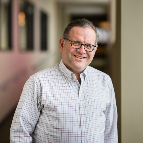 a man with glasses smiling