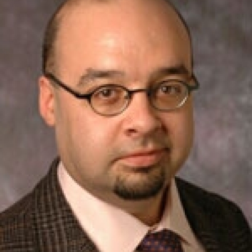 a man with glasses smiling
