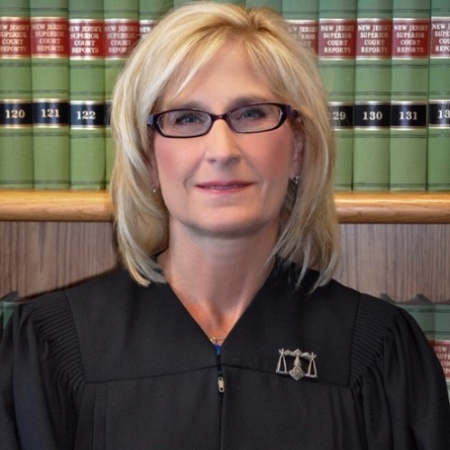 a blonde woman with glasses smiling