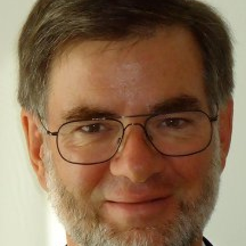 a man with a beard and glasses smiling