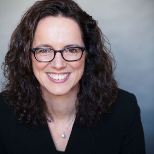 a woman with glasses smiling