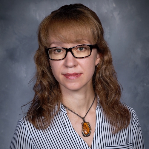 a woman with glasses smiling