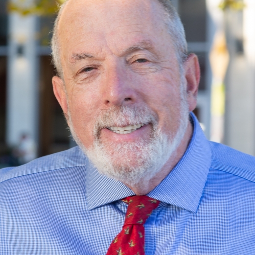 Man smiling wearing blue button down shirt and red tie