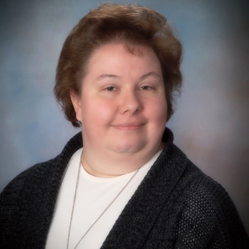 Woman grinning wearing white shirt and black sweater