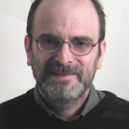Man grinning with glasses wearing black sweater