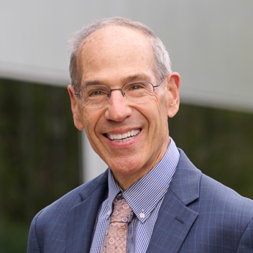 Man wearing glasses in blue suit smiling