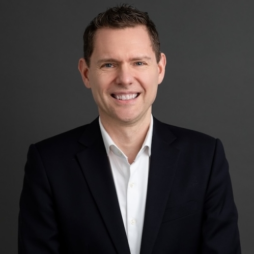 Man in black blazer and white shirt smiling