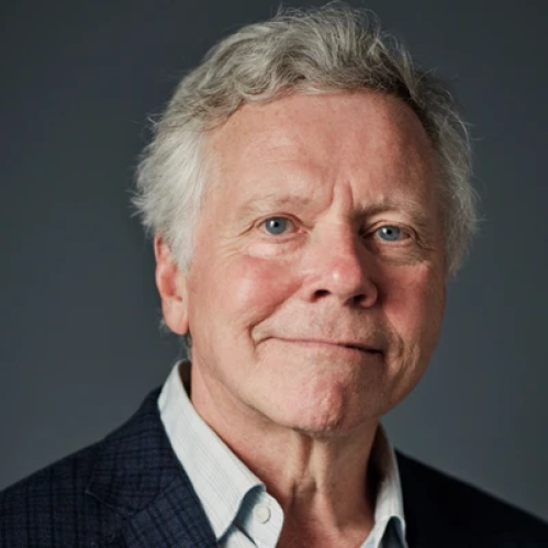 Man with gray hair in blazer and shirt smiling