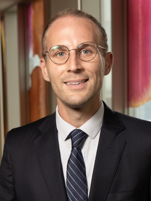 a man with glasses smiling