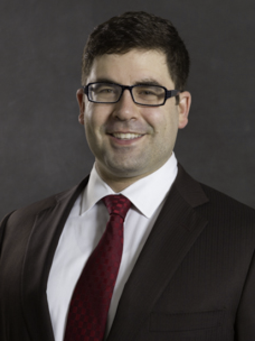 a man with glasses smiling