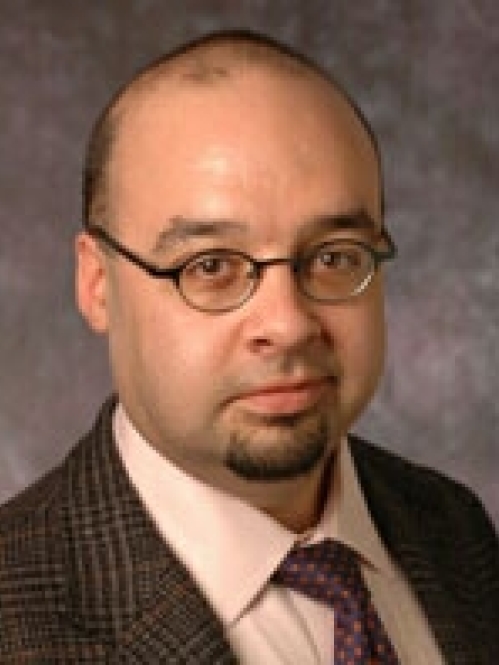 a man with glasses smiling