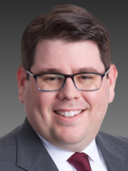 a man with glasses smiling