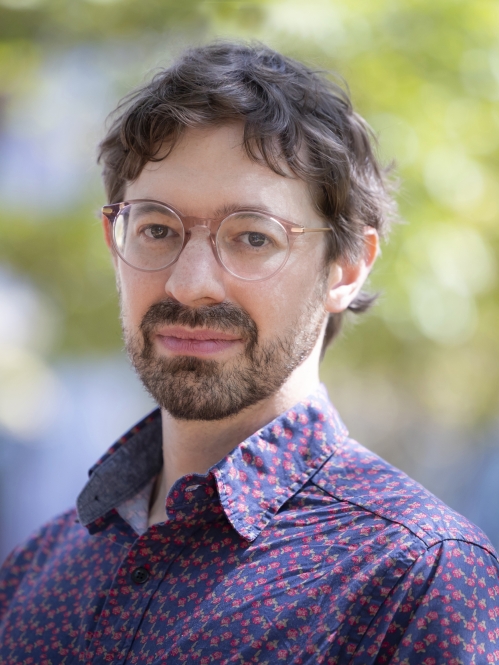 a man with a beard and glasses smiling