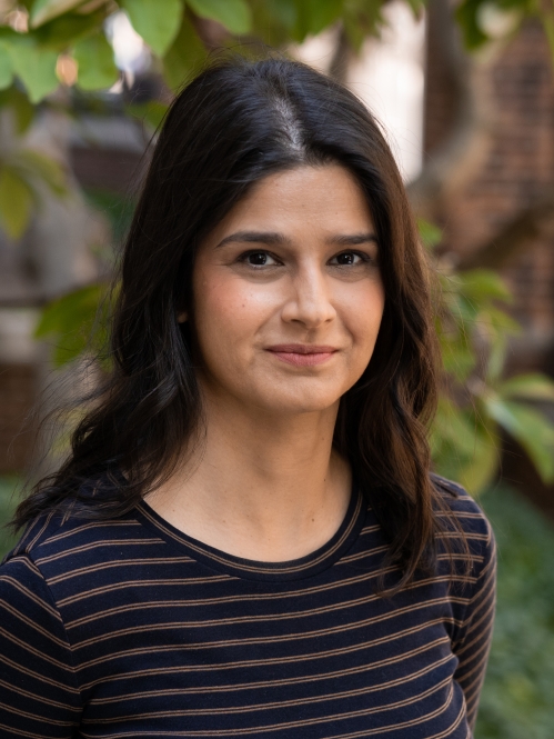 woman with long hair grinning outside