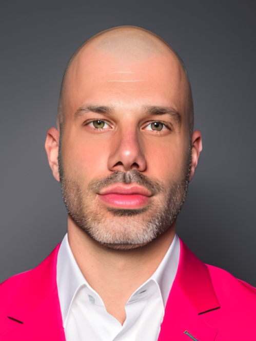 headshot of man wearing white shirt and hot pink blazer