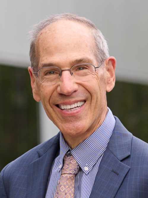 Man wearing glasses in blue suit smiling