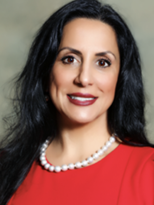 Woman smiling wearing red shirt and pearl necklace.